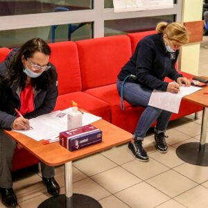 Dwie osoby wypełniające dokumenty w celu rejestracji
