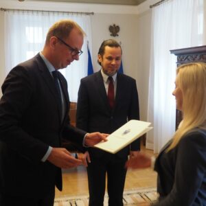 Prezydent wręcza dyplom Justynie Supel, w tle Rektor