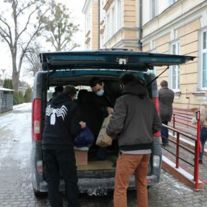 Delegacja wypakowuje podarunki z bagażnika samochodu