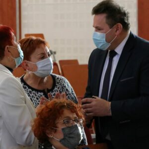 Prorektor Solecki rozmawia w auli z dwiema paniami (wszyscy w maseczkach)