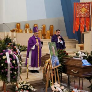 Wnętrze kościoła, trumna, zdjęcie Profesora, wieńce, w tle księża