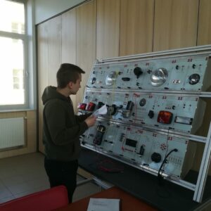 uczeń wykonuje część praktyczną konkursu polegającą na podłączeniu instalacji elektrycznej pojazdu na ściance dydaktycznej