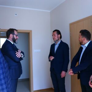 Zwiedzanie akademika, goście wraz z Rektorem w jednym z pokoi