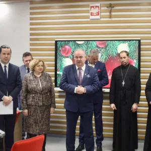goście stojący w sali podczas spotkania opłatkowego