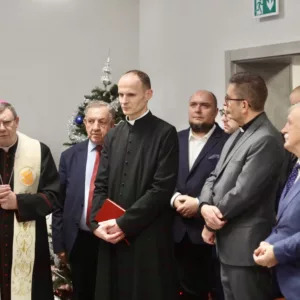 goście stojący w sali podczas spotkania opłatkowego
