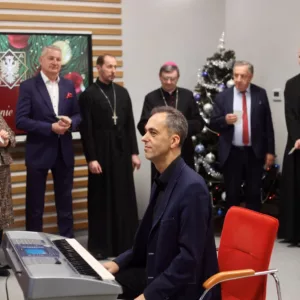 na pierwszym planie chórmistrz Piotr Szelążek, w tle zgromadzeni goście