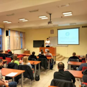 widok na salę z tablicą i rzutnikiem, na tablicy wyświetlana jest prezentacja