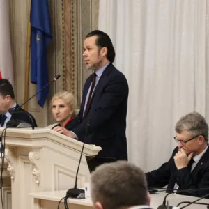 Rektor PANS przy mównicy, obok pozostali uczestnicy Sesji Rady Miejskiej w Przemyślu