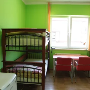 widok na pokój - dwa łóżka piętrowe oraz biurka z krzesłami, lodówka, szafa