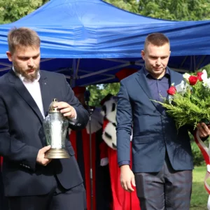 Składanie kwiatów i znicza pod obeliskiem