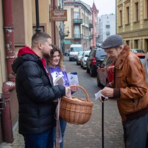 przechodnie częstują się pączkami