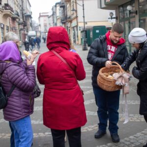 przechodnie częstują się pączkami