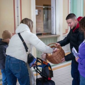 przedstawiciele PANS w Przemyślu częstują pączkami oczekujących na pociąg