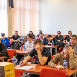 uczniowie w sali wykładowej wypełniają test
