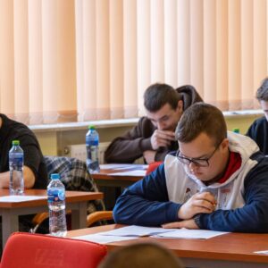 uczniowie w sali wykładowej wypełniają test