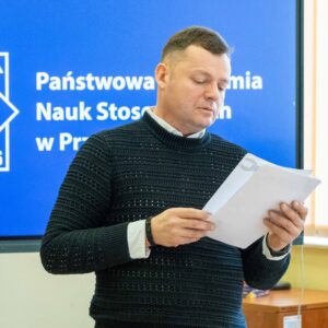 mgr inż. Rafał Hajduk trzyma testy w dłoniach