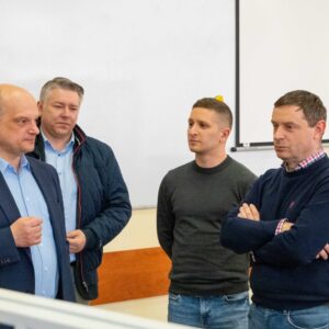 wykładowcy i nauczyciele rozmawiają przy tablicy
