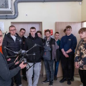 z przodu mgr inż. Robert Niedziałkowski z dronem, dalej uczniowie ze szkół ponadpodstawowych
