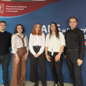 Pięcioro studentów na tle ścianki firmowej PANS