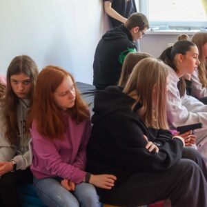 grupa uczniów siedzi na materacach
