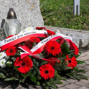 kwiaty i znicz pod pomnikiem pamiątkowym w Parku Lubomirskich