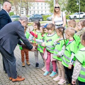władze uczelni rozdają dzieciom dyplomy i słodycze