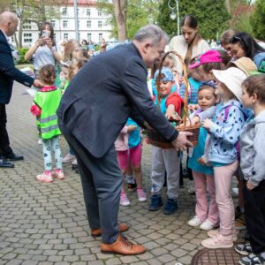 władze uczelni rozdają dzieciom dyplomy i słodycze