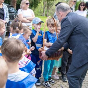 władze uczelni rozdają dzieciom dyplomy i słodycze
