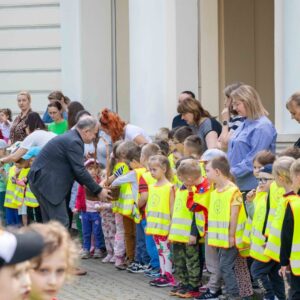 władze uczelni rozdają dzieciom dyplomy i słodycze