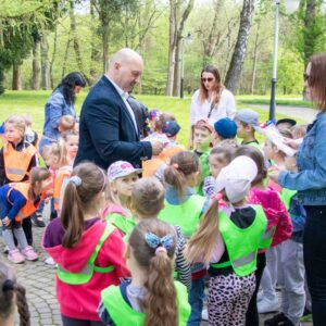 władze uczelni rozdają dzieciom dyplomy i słodycze