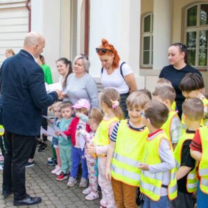 władze uczelni rozdają dzieciom dyplomy i słodycze