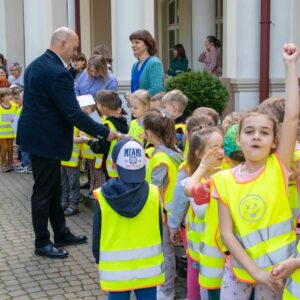 władze uczelni rozdają dzieciom dyplomy i słodycze