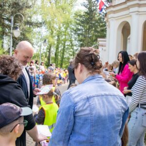 władze uczelni rozdają dzieciom dyplomy i słodycze