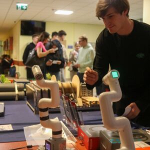 student przy stoisku z robotami