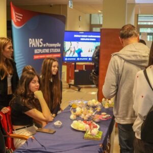 studentki i uczniowie przy stoisku z upominkami wielkanocnymi, w tle ścianka PANS