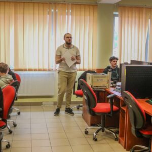 wnętrze sali komputerowej, przy stanowiskach siedzą uczniowie