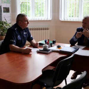 Nadkomisarz KMP oraz Kanclerz rozmawiają w gabinecie Kanclerza, siedząc przy stole