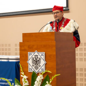 dr Sławomir Solecki - Prorektor ds. rozwoju i współpracy, przemówienie z mównicy z logo uczelni