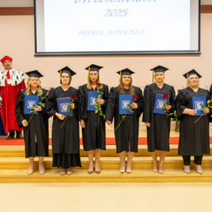grupa absolwentów z dyplomami ukończenia studiów
