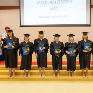 grupa absolwentów z dyplomami ukończenia studiów