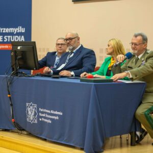 Moderatorzy i prelegenci pierwszego panelu przy stole konferencyjnym