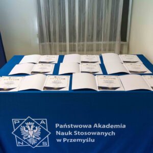 dyplomy ułożone na stole z obrusem z logo PANS w Przemyślu
