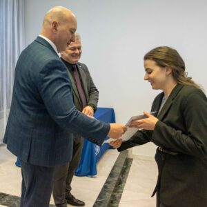 studentka odbiera dyplom z rąk JM Rektora dr. hab. Marka Delonga, prof. PANS