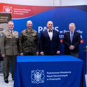 pamiątkowe zdjęcie grupowe przedstawicieli 20PBOT oraz PANS w Przemyślu, na tle ścianki uczelnianej