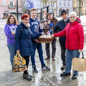 przechodnie częstują się pączkami