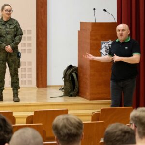 przedstawicielka Wojskowego Centrum Rekrutacji w Jarosławiu na scenie w Auli, po prawej stronie dr Paweł Łabuz, prof. PANS – Dziekan Wydziału Nauk Społecznych, Humanistycznych i Ochrony Zdrowia PANS