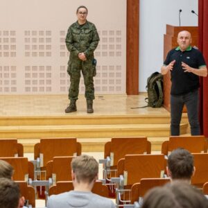 przedstawicielka Wojskowego Centrum Rekrutacji w Jarosławiu na scenie w Auli, po prawej stronie dr Paweł Łabuz, prof. PANS – Dziekan Wydziału Nauk Społecznych, Humanistycznych i Ochrony Zdrowia PANS
