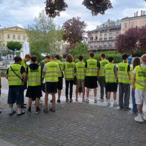 pamiątkowe zdjęcie grupowe studentów w kamizelkach odblaskowych z nazwą uczelni i kierunku studiów
