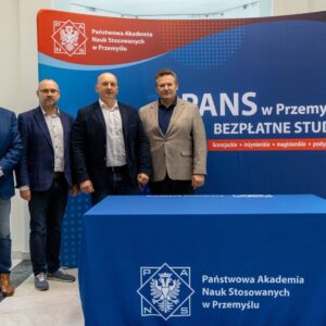 pamiątkowe zdjęcie grupowe na tle ścianki PANS w Przemyślu