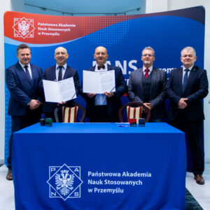 pamiątkowe zdjęcie grupowe na tle ścianki PANS w Przemyślu